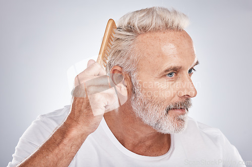 Image of Senior man, hair comb and brush on studio background for beauty, barber salon and cosmetics. Face of male model, brushing hairstyle and fashion for manly grooming, hair care and fresh morning routine