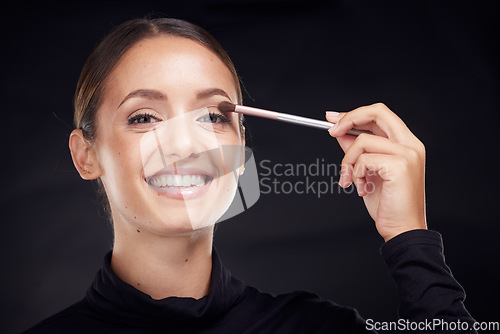 Image of Makeup, brush or portrait of woman in studio with beauty cosmetics, eyeshadow or facial products on black background. Makeup artist, smile or happy girl brushes face for luxury skincare grooming