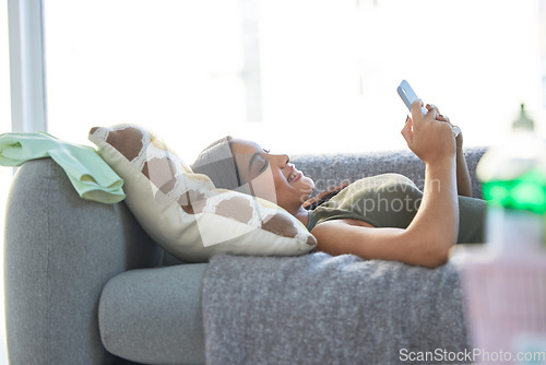 Image of Indian woman, phone and relax happy on sofa for social media, online communication and streaming video on web mobile app. Female, calm peace and relaxation or happiness watching meme on smartphone