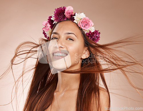 Image of Woman, portrait and flowers on crown, studio background and windy hair for healthy skincare in Brazil. Happy face, floral headband and model of beauty, spring fashion and natural makeup of eco plants