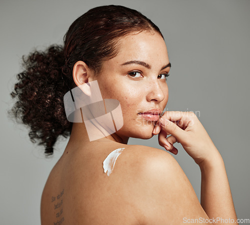 Image of Portrait, back and woman with cream, skincare and dermatology for wellness, health and against grey studio background. Latino female, girl and lotion for cosmetics, natural beauty and smooth skin