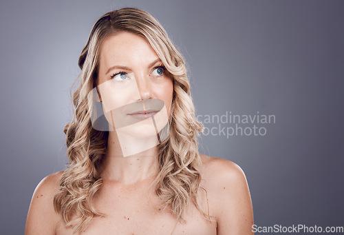Image of Hair, beauty and thinking with a model woman in studio on a gray background for a haircare treatment idea. Wellness, health and keratin with an attractive young female posing to promote natural care