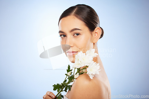 Image of Face portrait, skincare and woman with flower in studio on a blue background mockup. Organic makeup, floral cosmetics and female model with white plant for facial treatment, healthy skin and beauty.