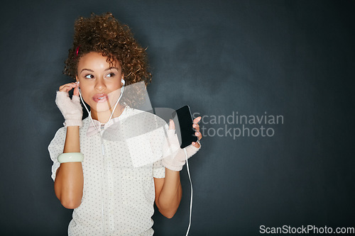 Image of Music, podcast and black woman with a phone for the radio isolated on a black background. Audio, thinking and African girl with a mobile streaming songs with mockup space on a studio backdrop