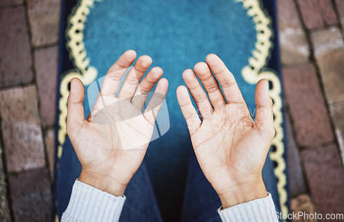 Image of Hands, muslim and praying in worship to Allah, god or creator on salah mat making dua on the floor. Hand of islamic man in pray for islam religion, spiritual or respect for belief or culture outside