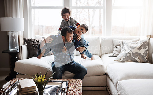 Image of Goofy, funny and bonding father with children on the sofa for playing, quality time and crazy fun. Love, happy and boy kids piling onto dad with energy on the couch of their family home together