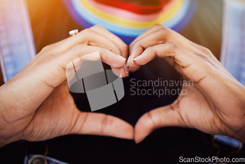 Image of LGBTQ, pride and hands with a heart sign for love, equality and solidarity of a gay woman. Rainbow, freedom and closeup of lesbian female with a hand symbol at a gay pride celebration festival.