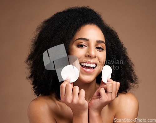 Image of Face portrait, skincare and black woman with cotton in studio isolated on a brown background. Wellness, cosmetics and happy female model holding facial pad or product for cleaning makeup for hygiene.