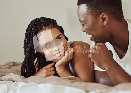 Image of Black couple, love and bedroom conversation while happy together on a bed in a house, apartment or hotel. Face of young man and woman in a healthy marriage with communication, understanding and care