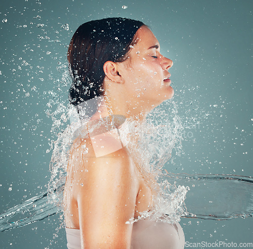 Image of Shower, wellness and water splash on woman for skincare hygiene and hydration isolated in a studio background. Skin, grooming and dermatology for young beautiful adult doing self care