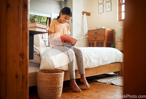 Image of Happy child reading on bed for home learning, language education and creative development in her bedroom. Smart, intelligent and Indian girl kid with English books for fun story and holiday activity