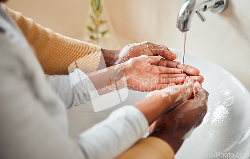 Image of People cleaning hands, soap and skincare with hygiene in bathroom, self care with skin and water for wash. Parent helping child, clean with quality time together and family home, health and wellness