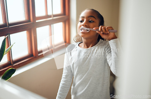 Image of Girl brushing teeth, dental and toothbrush for hygiene with clean mouth and fresh breath with oral health. Kid, cleaning with toothpaste in bathroom and wellness at family home with healthy gums