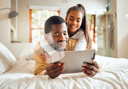 Image of Black family, tablet or education with a father and daughter lying together on a bed in their home for learning. Relax, internet and kids with a man and girl in a bedroom for growth or development