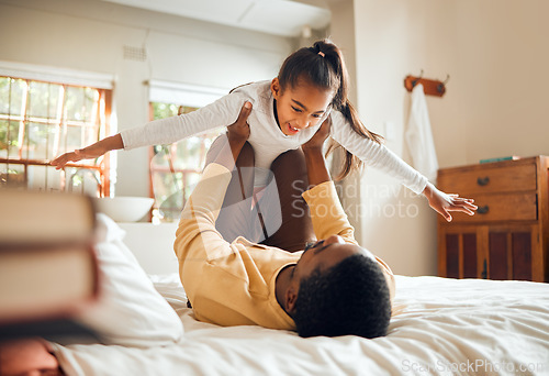 Image of Father, child and playing on bed flying for fun quality bonding time together indoors at home. Happy dad holding daughter in air with knees and arms in bedroom for playful relationship at the house