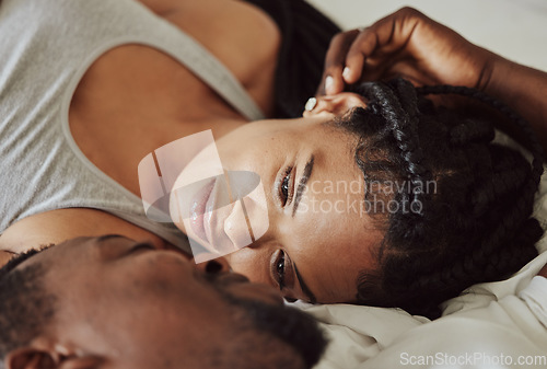 Image of Black couple, love and bedroom romance while happy and intimate on a bed at home, apartment or hotel to relax. Face of a young man and woman in a happy marriage with commitment, trust and care