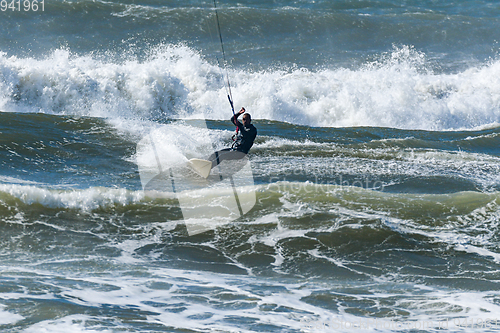 Image of Kitesurfer riding ocean waves