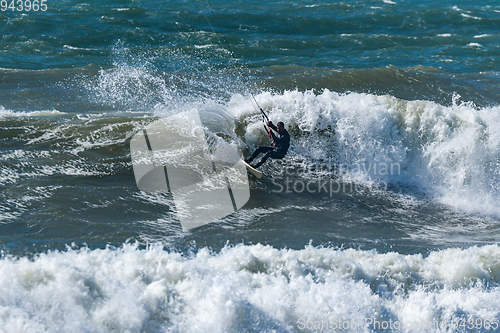 Image of Kitesurfer riding ocean waves