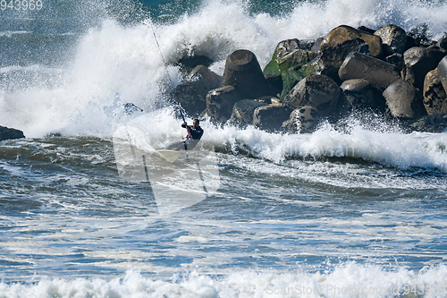 Image of Kitesurfer riding ocean waves