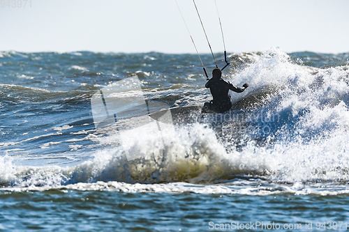 Image of Kitesurfer riding ocean waves