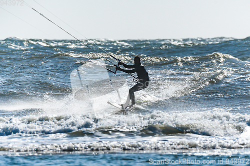 Image of Kitesurfer riding ocean waves