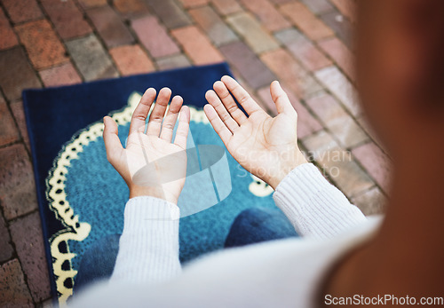 Image of Hands, islam and praying in worship to Allah, god or creator on salah mat making dua on the floor. Hand of islamic man in pray for muslim religion, spiritual or respect for belief or culture outside