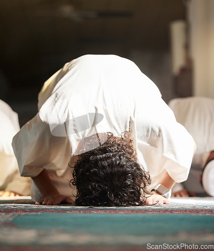 Image of Muslim, prayer and mosque with a man praying in faith or faith for fajr, dhuhr or asr, otherwise maghrib or ishaa in a group. Salah, worship or pray with islamic men in devotion for ramadan