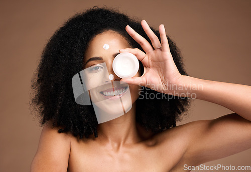 Image of Face, product and skincare with a model black woman in studio on a brown background for skin treatment. Portrait, container and beauty with an attractive young female posing to promote antiaging care