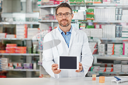 Image of Pharmacist man, shop and portrait with tablet screen, focus and focus for marketing, medication or sales. Medical professional, pharma expert and mobile digital tech in pharmacy for wellness with app