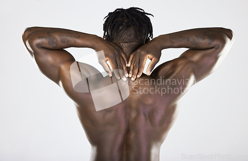 Image of Back, body and muscular with a model black man posing in studio on a gray background for fitness or exercise. Muscle, health and wellness with a strong male athlete posing or flexing for power