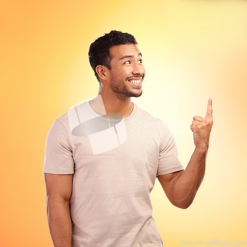 Image of Mockup, pointing up and man advertising in studio isolated on a yellow background. Thinking, branding and happy male model showing copy space for product placement, mock up or marketing promotion.