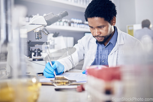 Image of Black man writing report for science experiment, scientist in lab for research to test and study for scientific innovation. Biotechnology in laboratory, focus and knowledge, pen and checklist.