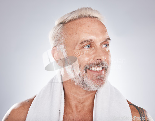 Image of Senior man, beauty and skincare while grooming, happy and clean after a shower with a towel on a gray background. Face of a old male model with a smile for cosmetics, dermatology and healthy skin