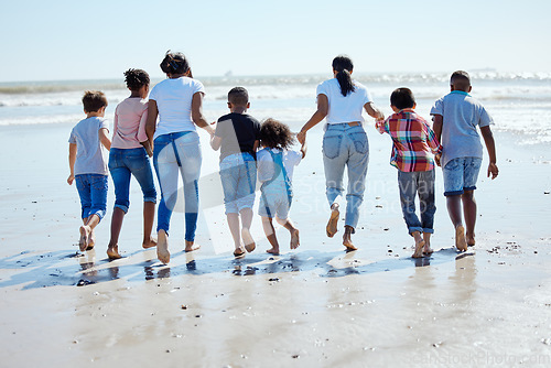 Image of Big family, beach walk and water for vacation, sunshine and bonding with interracial diversity by waves. Happy family, mother and holding hands for solidarity, care and love on holiday by sea