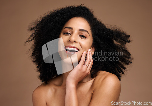 Image of Woman, studio portrait and afro with beauty, makeup and cosmetic wellness with hands, face or natural hair. Model, skincare and facial cosmetics, self care glow and smile by brown studio background