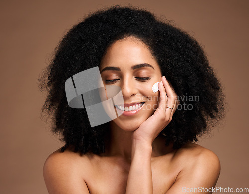 Image of Skincare, cream and black woman with smile for beauty, cosmetics and facial health promotion of product in studio. Happy African model with skin care, dermatology or sunscreen application on her face