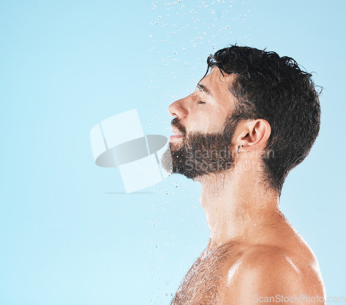 Image of Water, cleaning and face with man and beauty, shower for hygiene and grooming with skincare against blue studio background. Clean, model profile with water drops and natural cosmetic treatment mockup