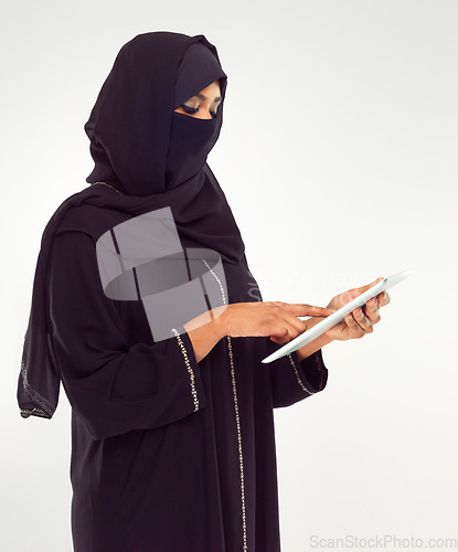Image of Woman, tablet and hijab of muslim for online islamic research against a white studio background. Female standing holding touchscreen with scarf reading news on islam, arabic or culture