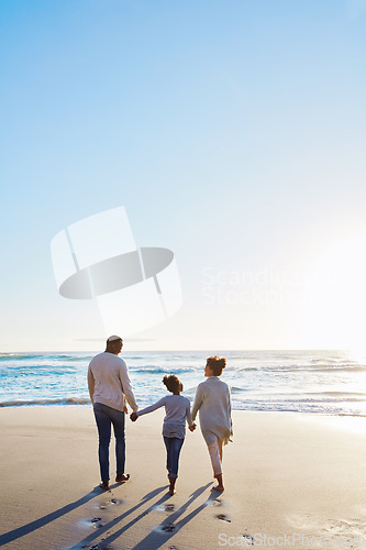 Image of Family, beach and walk during sunset on vacation or holiday relaxing and enjoying peaceful scenery at the ocean. Sea, water and parents with daughter, child or kid with childhood freedom