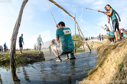 Image of Athletes go through mud and water