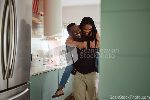Image of Black couple, piggyback and love while together in home kitchen with care and happiness in a marriage. Happy young man and laughing woman playing fun game while to bond in their house or apartment