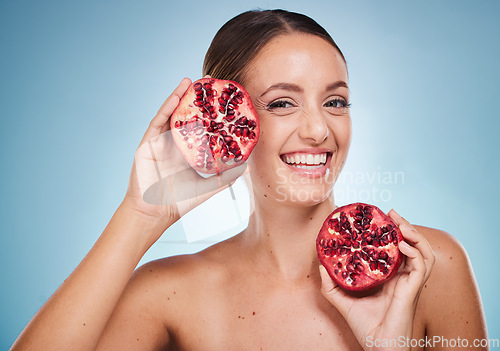 Image of Face portrait, skincare and woman with pomegranate in studio on a blue background. Organic cosmetics, beauty and female model with product, fruit or food for vitamin c, nutrition and healthy diet.