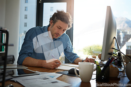 Image of Notebook, writing and planning with a businessman working on his desk in the office for growth or development. Strategy, mindset and mission with a male employee at work to write notes in his book