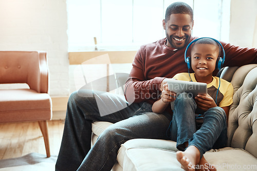 Image of Tablet, sofa and father with his son watching a funny, comic or meme video on social media. Happy, smile and African man streaming a movie with his boy child on mobile device while relaxing together.