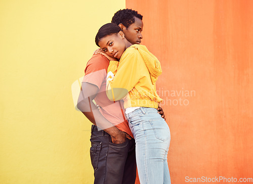 Image of Love, hug and comfort with a black couple together outside on a color wall background for romance or dating. Hugging, date and consoling with a man and woman holding each other in support or care