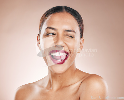 Image of Makeup, beauty and lipstick on a woman with tongue on teeth for cosmetics on a studio background for dermatology, color and salon mockup. Face of aesthetic model with a smile, glow and healthy skin