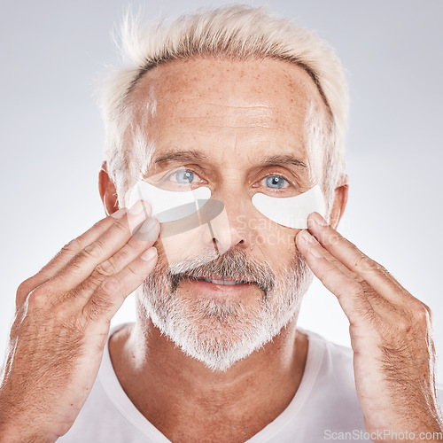 Image of Senior man with collagen eyes mask in skincare, dermatology facial and face cosmetics advertising in studio portrait. Elderly model with hands application of eye patch, anti aging product and beauty