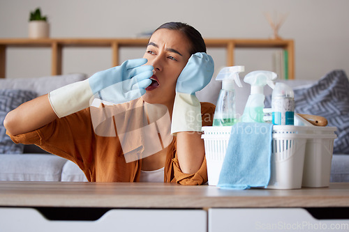 Image of Cleaning, yawn and tired with a woman housekeeper yawning while working in a home as a cleaner. Clean, bored and hygiene with a female suffering burnout from housekeeping as a maid with disinfectant