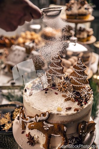 Image of Woman powdering gingerbread cake