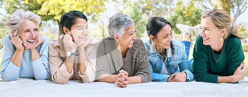 Image of Senior women, friends and relax on picnic in park for bonding, wellness and rest on blanket. Happiness, comic and group of elderly people in retirement talking, laughing and enjoying time in nature.